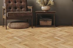 oak wooden herringbone flooring in hallway with dark walls and a chair